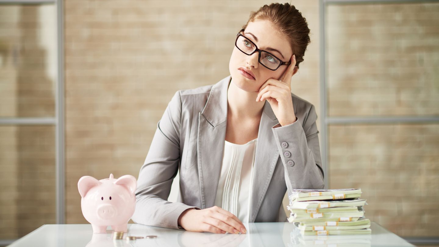 Concerned Woman With A Piggy Bank And Money Stacks